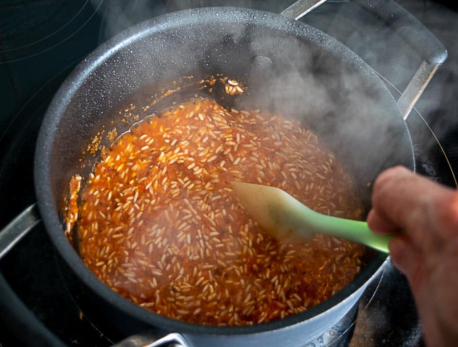 Adding the tomato chipotle mixture to the browned rice