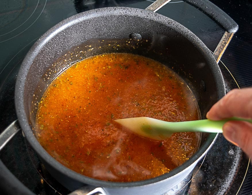 Adding the aromatics and stock to the mixture