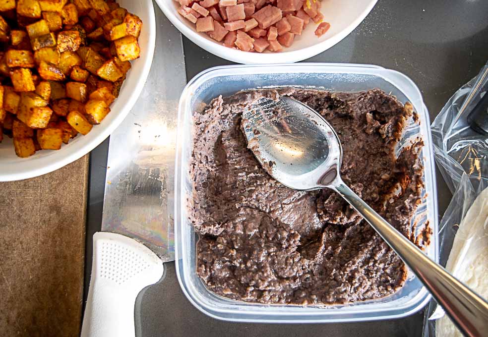 Tupperware container full of refried beans