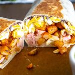 Breakfast burritos next to a dish full of homemade Jalapeno Hot Sauce