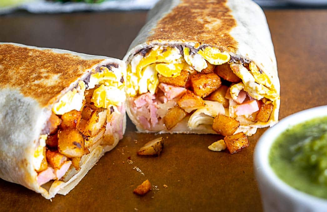 Breakfast burritos next to a dish full of homemade Jalapeno Hot Sauce