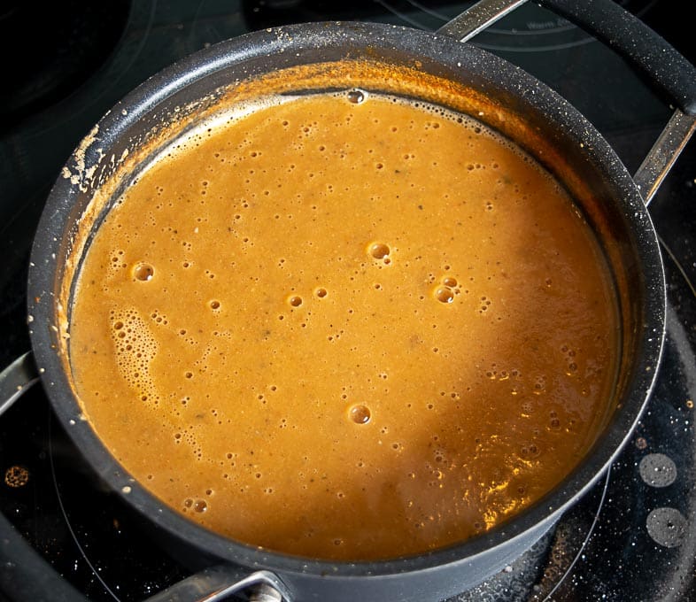 adding blended soup back to the pot