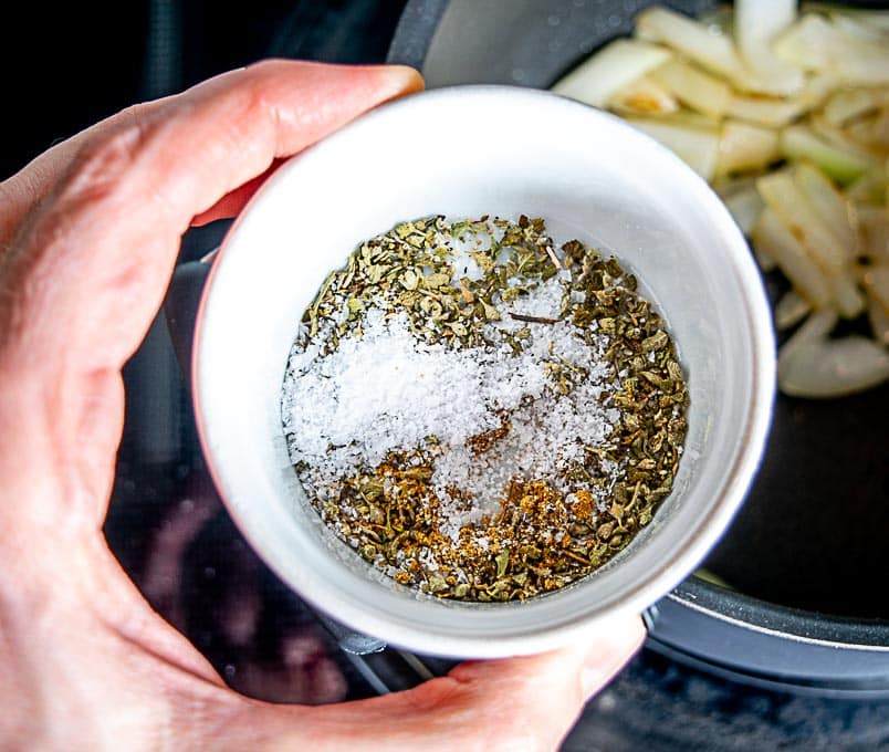 Adding Mexican oregano to the onion and garlic