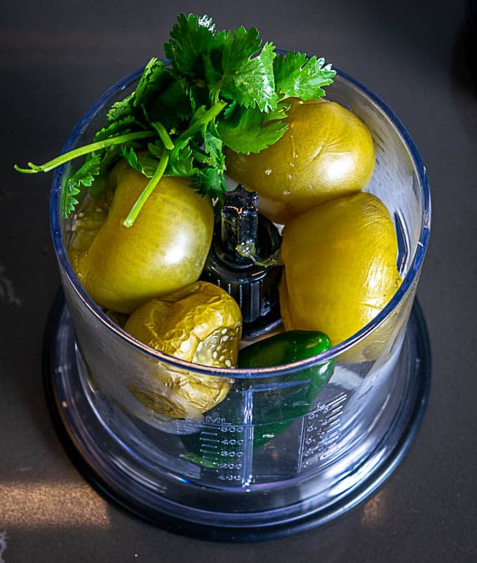 Adding the other ingredients to the blender for the Avocado Salsa Verde