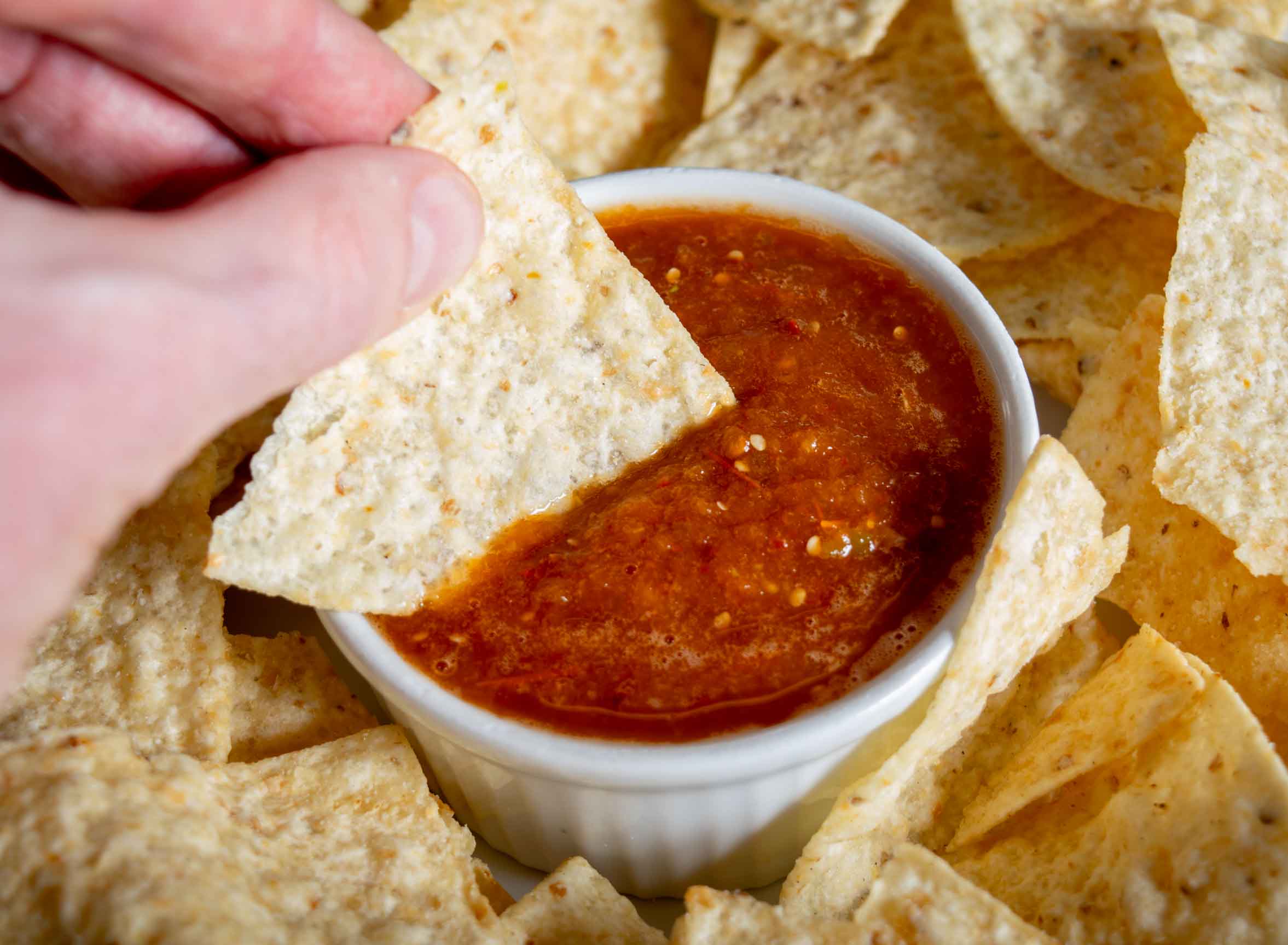 dipping a chip into morita chile salsa